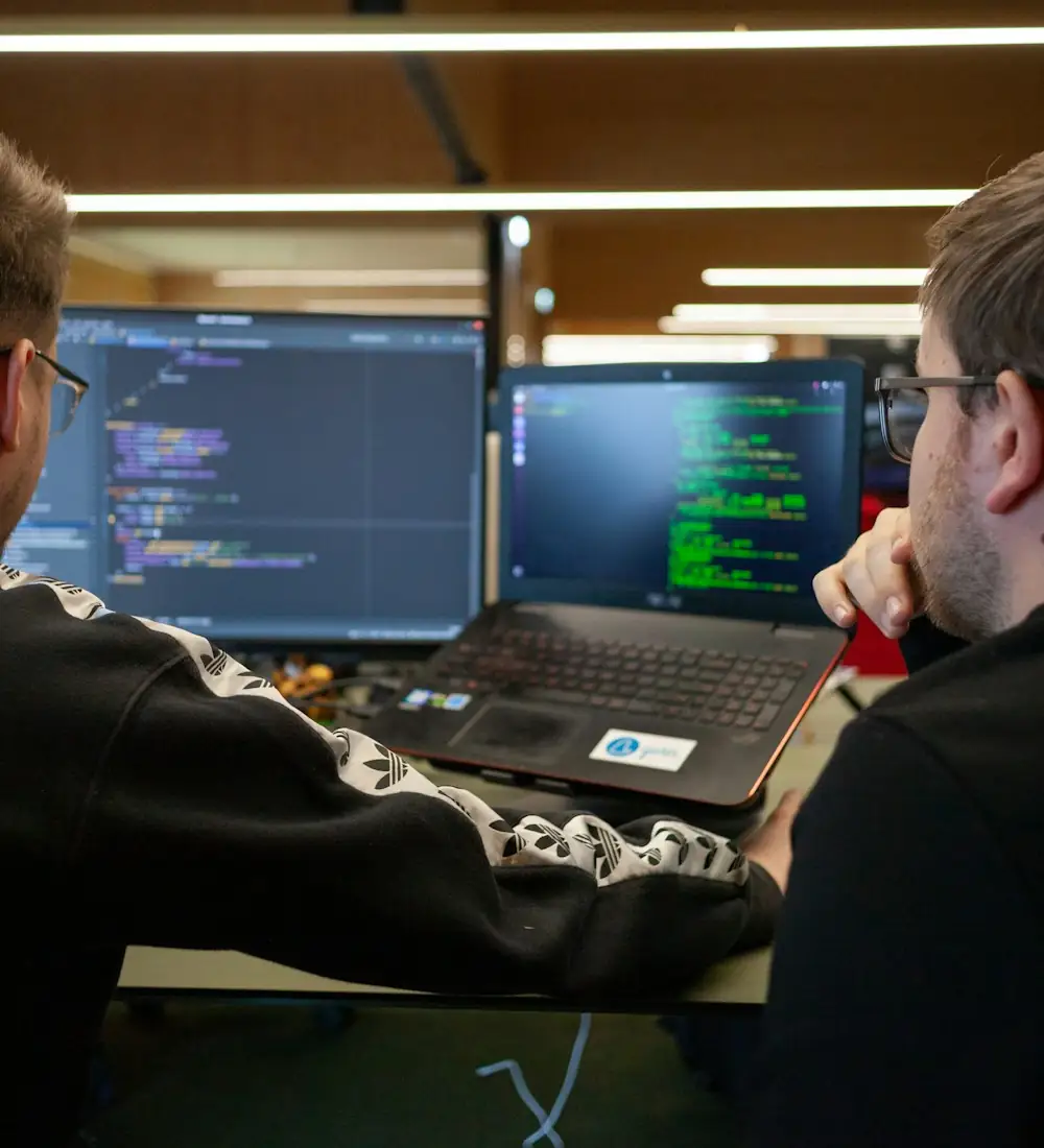 Двое разработчиков обсуждают проект у ноутбука