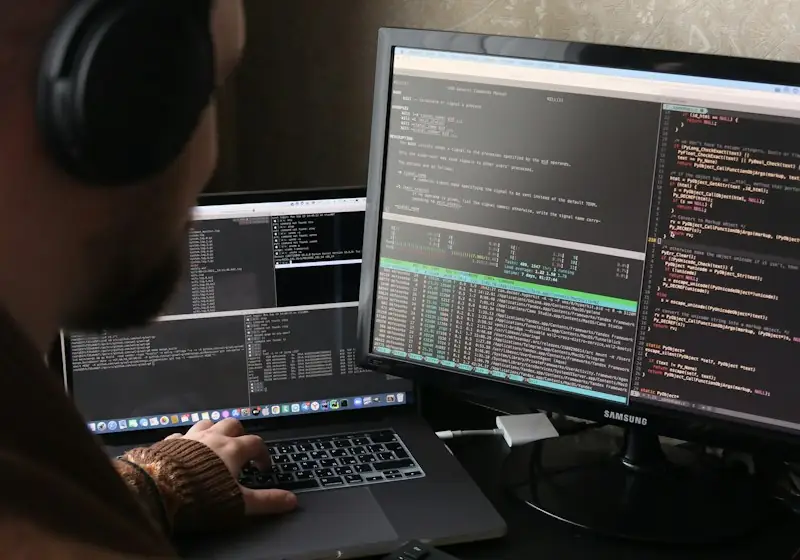 Разработчик в наушниках работает за компьютером